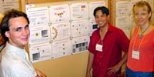 Sawyer B. Fuller (S.B. 2000, S.M. 2003); Brian Chow, a Ph.D. student in the Media Lab; and postdoctoral associate Andrea Lomander of the Center for Biomedical Engineering review posters about scientific research displayed at the conference center.