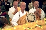 Venerable G. Kato of the New England Peace Pagoda in Leverett, Mass., leads a prayer during the blessing ceremony for the exhibit of Buddhist relics at MIT. Behind him, also from the New England Peace Pagoda, are Brother Tow-Bee (left) and Brother Temm (right). Relics in the touring exhibit will eventually be enshrined in a 500-foot Maitreya Buddha statue being built in Northern India.