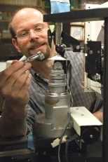 Professor Michael Yaffe loads a tiny protein crystal onto an X-ray diffractometer machine in order to study its structure.