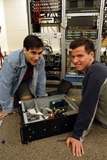 Graduate student Keith J. Winstein (left) and junior Joshua Mandel check the circuit board inside a computer that hosts the new campus-wide music library they designed.