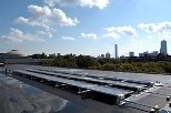 A solar panel array on the roof of the Student Center absorbs rays and reflects the Boston skyline.
