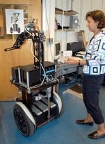 Una -May O'Reilly, co-principal investigator for MIT's newest robot, watches as Cardea lets itself out the door of the lab to go for a stroll down the hall.