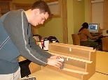 Will Etheridge sets up a beam-bending demonstration using a solid piece of wood (top), five bonded wooden strips (middle) and five unbonded strips.