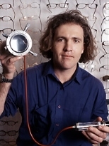 Saul Griffith holds part of his lens molding device that can produce any eyeglass prescription lens quickly and inexpensively.