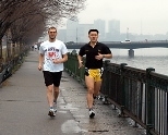 Triathletes Ken Ross (left) and Harn Wei Kua train by the Charles. Ross posted a time of 3:13 in the Boston Marathon.