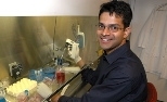 Broad Institute researcher Vamsi Mootha works with cells in the lab.