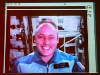 Alumnus Mike Fincke appears at his 15th reunion on a 30-foot screen in Kresge Auditorium via video teleconference from the International Space Station.