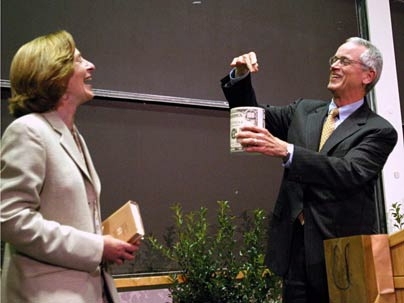Noting that a provost recognizes the "value of resources," Charles Vest, the 15th president of MIT, hands the 16th president, Susan Hockfield, a can of shredded money. Dr. Hockfield is currently the provost of Yale.