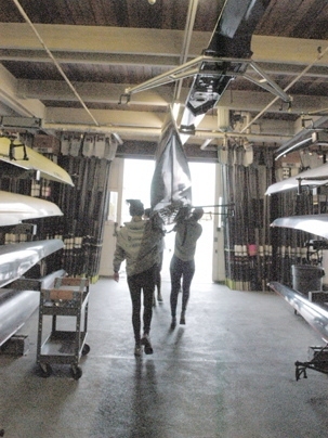 Members of the Cambridge '99 rowing club, from Cambridge, England, carry the MIT boat they will use to the river from MIT's Pierce Boathouse to practice for their race Sunday during the Head of the Charles Regatta.