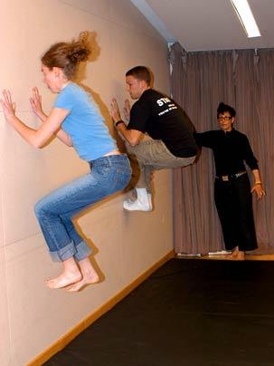 Students "climb the wall" during a visit from Streb, rear, after learning some of her extreme movement techniques.