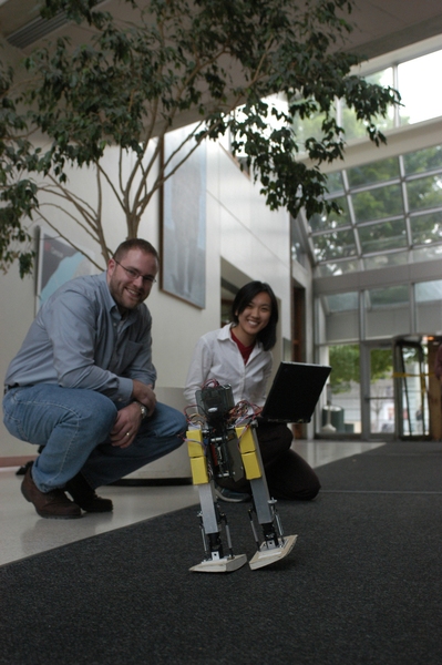 Postdoctoral associate Russ Tedrake and alumna Teresa Weirui Zang watch their robotic toddler navigate the medical building foyer.