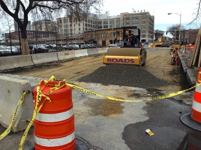 Workers begin paving a section of Massachusetts Avenue between Vassar and Albany streets on Friday, April 8.