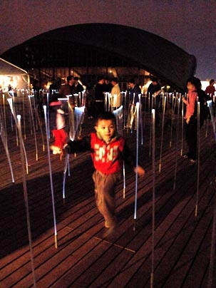 'White Noise/White Light' lights up May 2 as Yi Fan runs through the exhibit Monday evening on Kresge Oval. The boy's father is a Sloan professor visiting from Beijing.