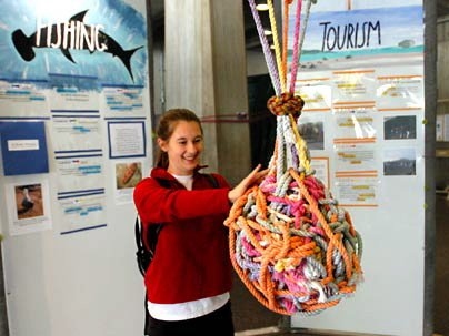 Freshman Lissa Riley, who traveled to the Galapagos Islands as part of MIT's Terrascope program, works on a knot displayed in the lobby of Building 13 as a metaphor for the complexity of pleasing all of the stakeholders in the Galapagos, from residents to tourists and from the government to the ecosystem.