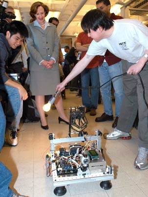 Graduate student Aaron Tan shows President Susan Hockfield how to direct a robot's movement with light during a May 5 presentation by the class Robotics Science and Systems I, organized in honor of Hockfield's inauguration.