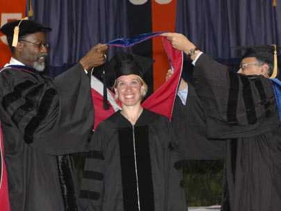 Chancellor Phillip Clay, left, and head of the department of brain and cognitive sciences Mriganka Sur, right, bestow a Ph.D. hood upon Charlene Ellsworth at MIT's hooding ceremony on Thursday, June 2.
