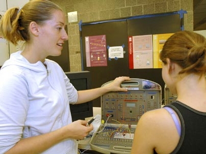 Laura Waller, an MIT doctoral candidate in electrical engineering, discusses how to make a metal detector with one of the high school girls participating in this summer's Women's Technology Program.