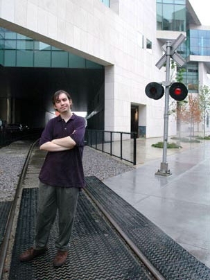 Freshman Anthony Rizos stands on the tracks by MIT's new brain and cognitive sciences complex earlier this month. Rizos turned his love of trains into a job at Amtrak.