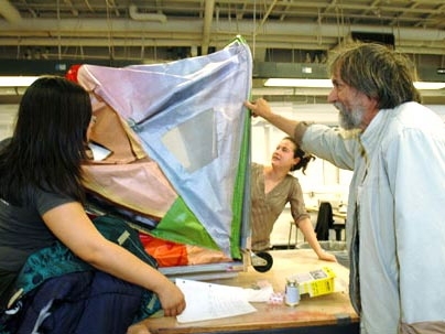 Marisa Cheng, a grad student in urban planning, left, and Celina Balderas, a junior in architecture, show Professor Jan Wampler how their portable homeless shelter opens up.