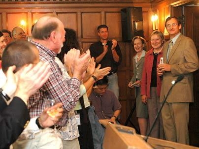 New Nobel laureate Richard R. Schrock, right, enters a press conference to a standing ovation on Oct. 5 at MIT. To his right is his wife, Nancy F. Carlson (in pink), and MIT President Susan Hockfield.