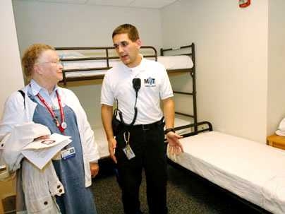 Priscilla Gray gets a tour of the new bunk house for ambulance workers from Nicolas Wyhs '05 on Oct. 19.