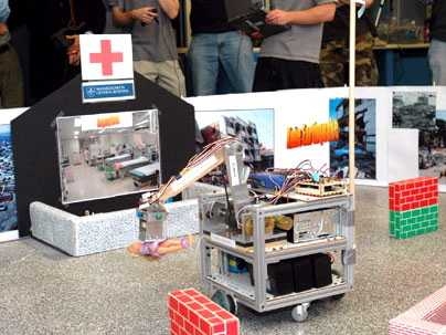 A rescue robot carries a doll, representing a victim of disaster, to the 'emergency room' during the course 2.12 demonstration held Wednesday, Dec. 14, in the d'Arbeloff Lab.