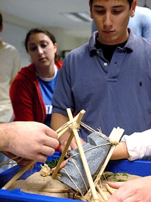 Senior Ira Simkhovitch helps move a model of an Easter Island head.