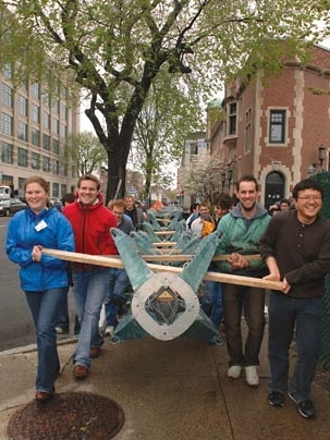 MIT graduate students carry the frame of a 35-foot mini-skyscraper down Massachusetts Avenue in preparation for its erection in front of the MIT Student Center. The structure weighs about 1,000 pounds. The students are, from left, Rebecca Edson, Peter Schmitt, Philippe Block and Young-Ju Kim.