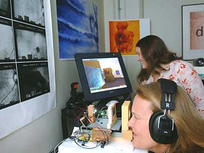 Elizabeth Goldring, foreground, looks into 'seeing machine' to take a virtual tour of a gallery using a joystick. Her assistant, Jackie McConnell, is at right.