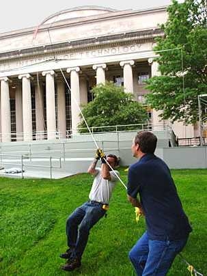 Gary Cunha of facilities, right, gets some help from John Grenier of Atlantic Plant Maintenance on Friday, June 2, to haul up the sail that will shade the stage during Commencement on Friday, June 9.