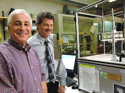 Professors Robert Cohen and Michael Rubner pose in Rubner's lab with equipment they use to try to mimic the watermaking abilities of the Namib Desert beetle.