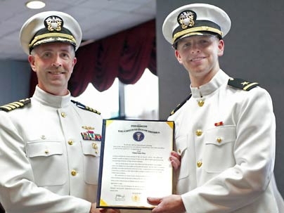 Rear Adm. (Select) Tom Eccles hands Ensign David Legault his Navy commission on Friday, June 9. Earlier in the day, Legault received his S.B. in nuclear science and engineering.