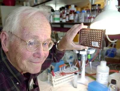 In a photo from 2002, Professor Vernon Ingram holds up cell cultures that he and senior technical associate Barbara Blanchard worked with during their research on the beta-amyloid plaques that attack the brains of Alzheimer's patients.