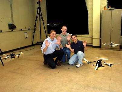 Jonathan How, a professor in aeronautics and astronautics, joins graduate students Brett Bethke, center, and Mario Valenti, right, in demonstrating their "hands-off" technique of simultaneously controlling four fully-autonomous flying vehicles using a PC.