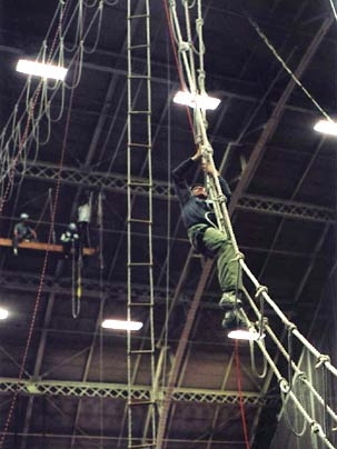 An M.B.A. student scales a rope ladder during an MIT Sloan School of Management course aimed at honing leadership and listening skills.