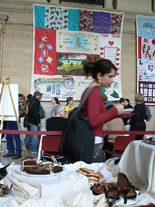 Freshman Dayanna Garcia surveys the sampling of chocolate treats at MIT's World AIDS Day fundraising and educational event in Lobby 10. Panels from the AIDS Memorial Quilt hang in the background.