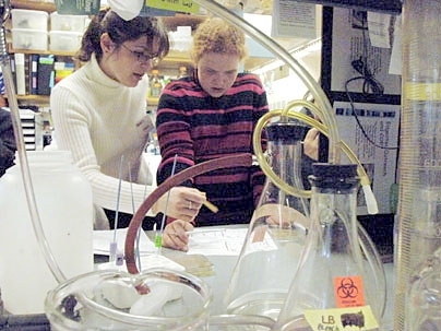 Postdoc Joanna Klapacz, left, works with Kennedy-Longfellow School sixth grader Ellie Montgomery in a genetics lab in the Edgerton Center program.