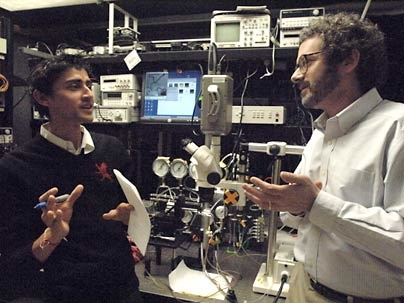Graduate student Manu Prakash (left) and Professor Neil Gershenfeld discuss new applications for their microfluidic chips, which can carry on-chip process control information.