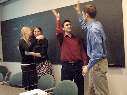 Biodiesel@MIT first-year students Katie Rowe, left, and Katrina Ellison embrace while junior Joe Roy-Mayhew, left, and senior Matt Zedler high-five. The group had just learned they had won the national Ecomagination Challenge for their initiative to turn used vegetable oil into biodiesel fuel for MIT campus vehicles.