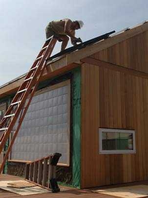A volunteer installs the first solar panel on MIT's entry in the Solar Decathlon.