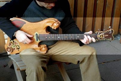 Recent graduate Adam Leed strums a few chords on his Hobby Shop-made electric guitar.