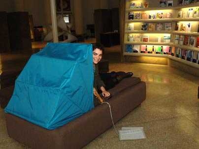 Sofia Ponte, an MIT graduate student in architecture, peers around the  canopy of Dreaming Lounge, on display in Barker Library through Feb. 15. Ponte created the furniture prototype for what she hopes will be a refuge for students needing respite from too much analytical thought.