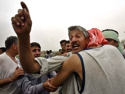 An Iraqi man gestures as he greets his son after he was released from the Abu Ghraib prison in Baghdad in May 2004.