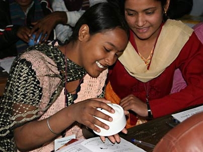 Priyanka Kumari and Shashi Pallavi try out the uBox, a 'smart' pillbox that metes out medication at a prescribed rate, at a recent training session in India.