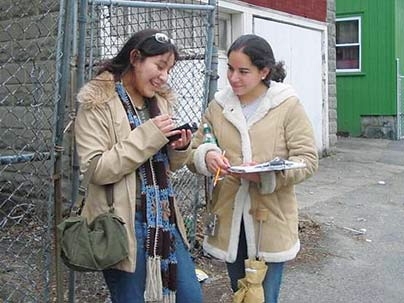 MIT was recently named to the President's Higher Education Community Service Honor Roll for exemplary service efforts and service to disadvantaged youth for the success of its MIT@Lawrence project. This photo, taken in 2004, shows MIT student Claudia Canepa and Lawrence resident Rebecca Camargo as they map properties in the city's North Common neighborhood.