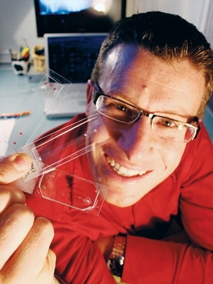 Roman Stocker, the Doherty Assistant Professor of Ocean Utilization, holds microfluidics devices.