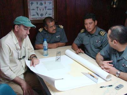 MIT researcher Nicholas Makris, left, works with Mexican navy officials to plan the deployment of acoustic sensors in the waters near Isla Socorro while on transit from Manzanillo to Socorro.
