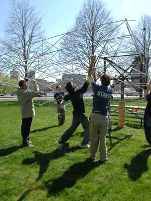 MIT students work on a new kind of solar generator that employs low-cost materials. Here they mount the frame of the concentrator (which will be mounted with mirrors) on the base near Tang Hall on Memorial Drive.