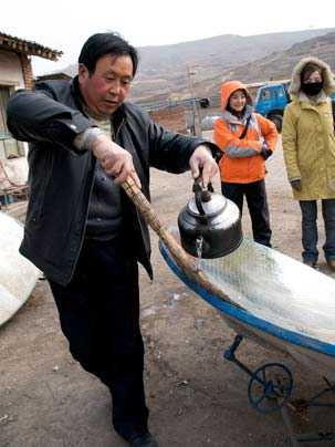 Tao Laoban works at cleaning one of the concrete solar cookers used in Tibet. A team of students, including some from MIT, has developed a more portable solar cooker.