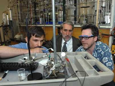 Chemistry professor Jonas Peters, Dan Nocera, Henry Dreyfus Professor of Energy, and Chris Cummins survey Nocera's piece of their solar energy work on artificial photosynthesis in Nocera's lab.